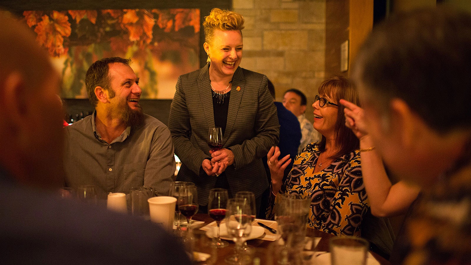 Sommelier Emily Wines laughing with a group of diners.